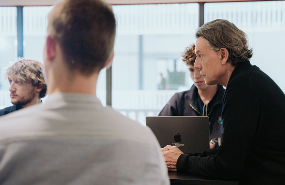 Gesch&auml;ftsmann diskutiert mit Teamkollegen bei einem Meeting am Laptop in einem modernen B&uuml;ro