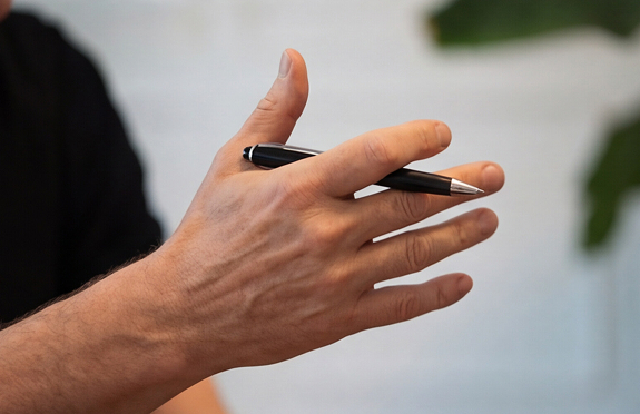 Hand mit Kugelschreiber gestikuliert w&auml;hrend eines Gespr&auml;chs oder einer Erkl&auml;rung