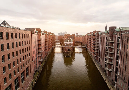 Historische Speicherstadt in Hamburg mit Backsteingebäuden und Kanal bei Sonnenuntergang