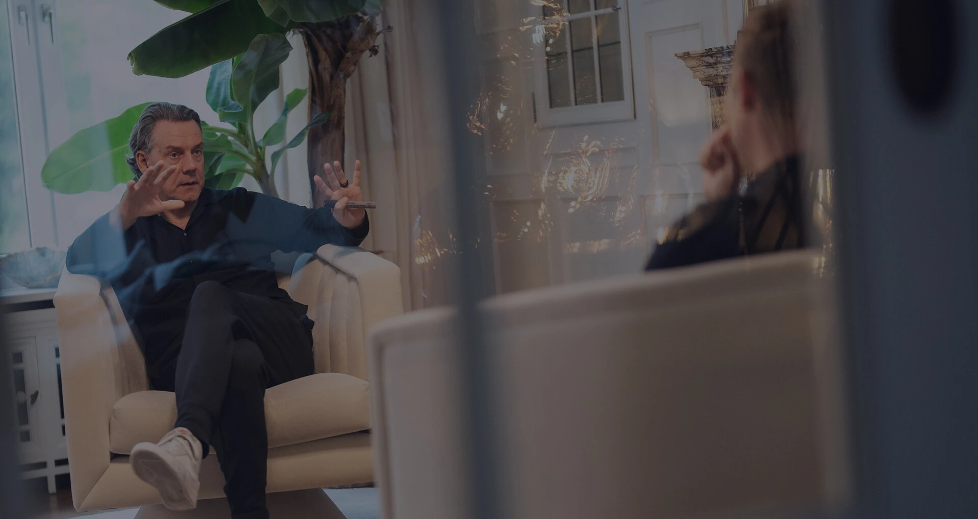 Zwei Männer sitzen sich in einem hellen Raum gegenüber und führen ein Gespräch in einer Coaching- oder Beratungssituation