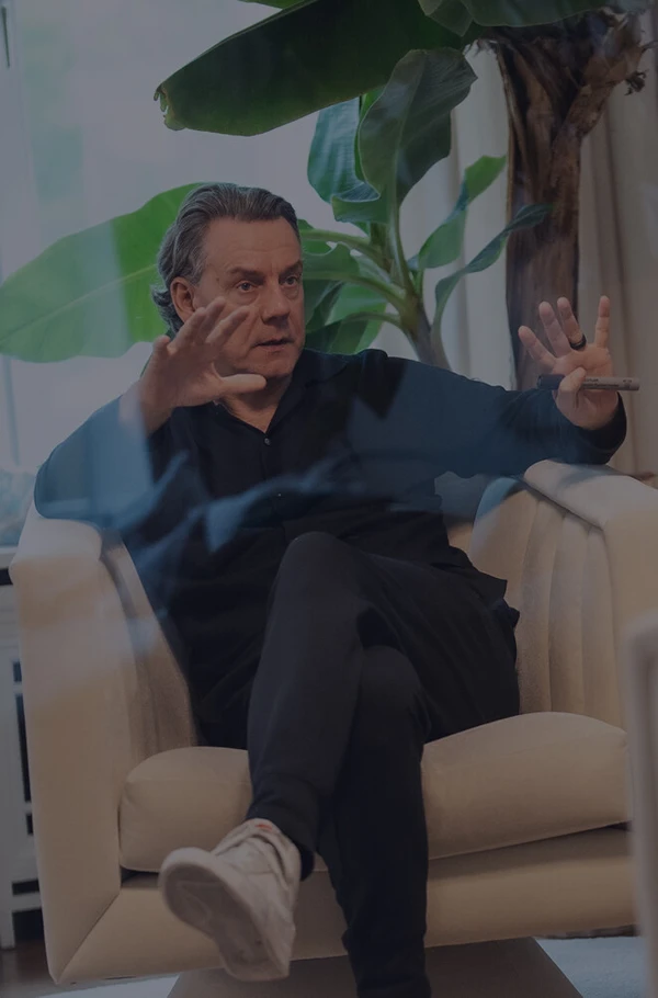 Coach erklärt etwas während eines Beratungsgesprächs mit Klient auf Sofa im hellen Raum