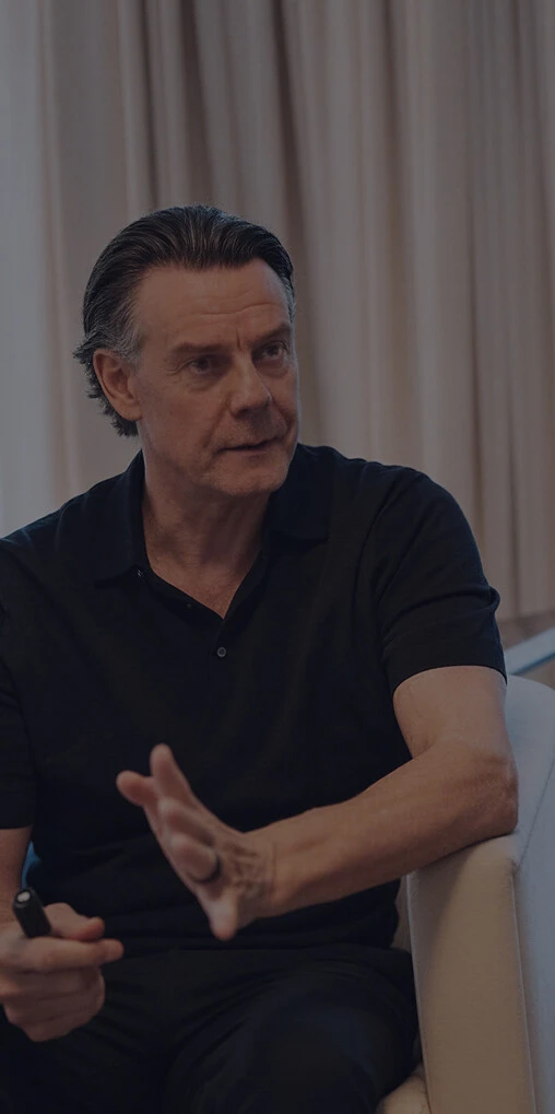 Zwei Männer sitzen sich in einem hellen Raum gegenüber und führen ein Gespräch in einer Coaching- oder Beratungssituation