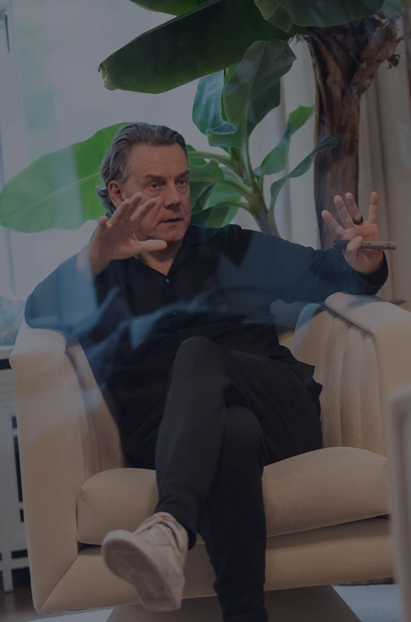 Zwei Männer sitzen sich in einem hellen Raum gegenüber und führen ein Gespräch in einer Coaching- oder Beratungssituation