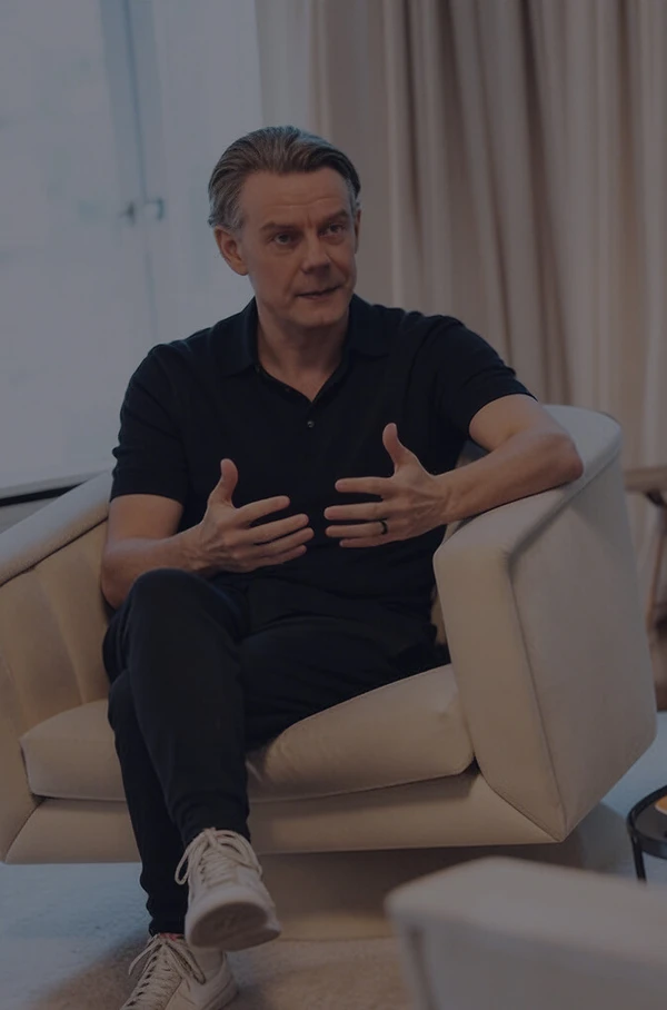 Zwei Männer sitzen sich in einem hellen Raum gegenüber und führen ein Gespräch in einer Coaching- oder Beratungssituation